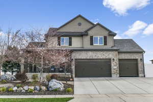 Craftsman house with paver pathways to the covered front porch.  Exterior features brick, cement board and stucco.