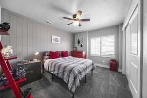 Upstairs bedroom which features an shiplap accent wall, plantation shutters, newer carpet and newer paint.