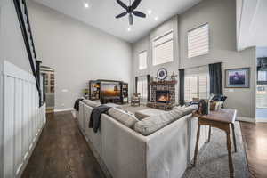 Two-story great room basking in natural light, stunning rock fireplace, hardwood floors, and newer carpet.
