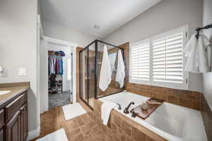 This spa style primary main level bath offers dual vanity, oversized soaking tub, separate shower and walk-in closet.