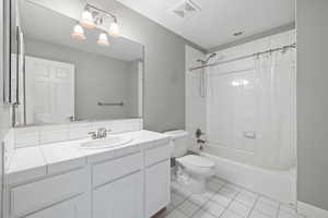Full bath featuring vanity, tile patterned flooring, toilet, shower / bathtub combination with curtain, and visible vents