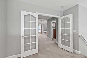Corridor with baseboards, an upstairs landing, and carpet flooring