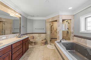 Bathroom with a sink, tile walls, a tub with jets, double vanity, and a stall shower