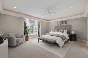 Bedroom with ornamental molding, baseboards, a tray ceiling, and light colored carpet