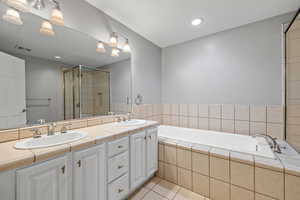 Bathroom featuring a sink, visible vents, tile patterned flooring, and a stall shower