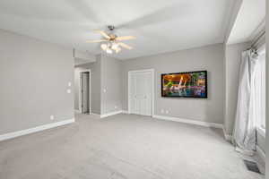 Spare room with visible vents, ceiling fan, baseboards, and light carpet