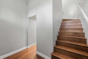 Stairway with baseboards and wood finished floors