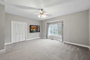 Unfurnished bedroom featuring a closet, baseboards, visible vents, a ceiling fan, and carpet flooring