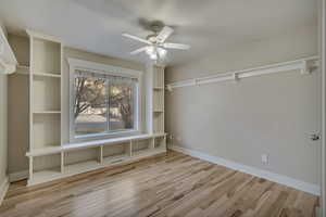 Walk in closet featuring wood finished floors, ceiling fan