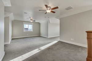 Bonus room with, a ceiling fan, carpet floors, and vaulted ceiling