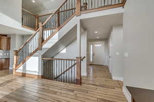 Vaulted entryway recessed lighting, stairway, and hardwood / wood-style floors