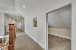 Hall with light carpet, lofted ceiling, and recessed lighting
