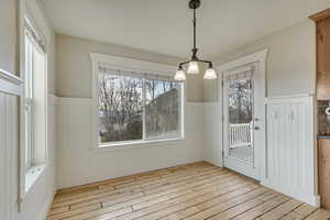 Dining area featuring light wood-style floors and wainscoting