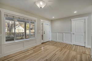 Foyer entrance with a decorative wall, recessed lighting, and wood floors