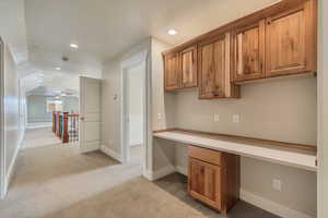 Office area featuring, recessed lighting, built in study area, ceiling fan, and light colored carpet