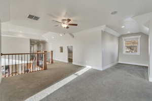 Interior space loft, featuring ceiling fan, vaulted ceiling
