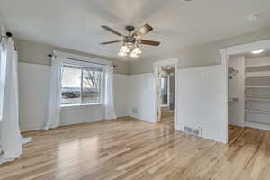 Bedroom with  a wainscoted wall, and wood finished floors
