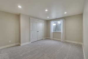 Bedroom featuring a closet, baseboards, recessed lighting, and carpet flooring