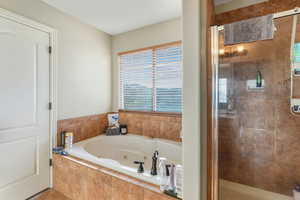 Bathroom featuring a stall shower and a tub with jets