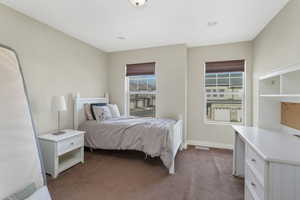 Bedroom featuring baseboards and dark carpet