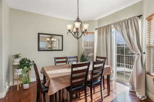 Dining room featuring a chandelier, wood-type flooring, and baseboards