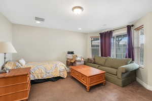 Carpeted bedroom featuring visible vents, baseboards, and recessed lighting
