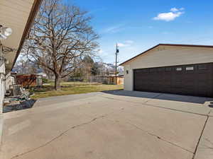 Detached garage featuring central air condition unit and fence