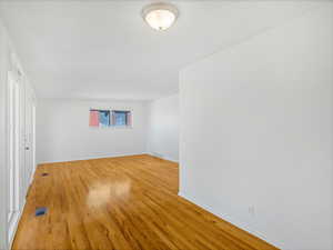Unfurnished room featuring light wood-style floors, baseboards, and visible vents