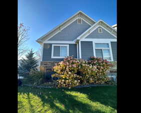 View of front of home with a front lawn and stone siding
