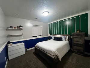 Bedroom with carpet flooring, visible vents, a textured ceiling, and baseboards