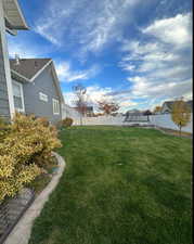 View of yard with a trampoline and fence