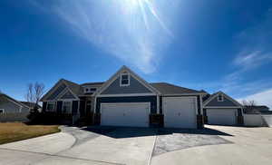 View of front of house featuring driveway, fence, and an attached garage
