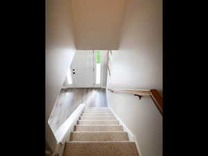 Stairs featuring wood finished floors and baseboards