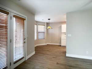 Unfurnished dining area with baseboards and wood finished floors