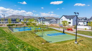 View of basketball court with a mountain view, a yard, and a residential view