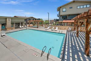 Community pool with a pergola, a patio area, and a community hot tub