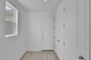 Corridor featuring light wood-type flooring and recessed lighting