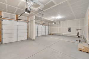 Garage featuring a garage door opener and electric panel