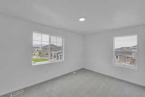 Carpeted spare room featuring baseboards and a residential view