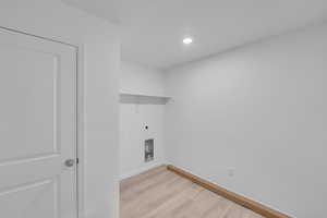 Laundry area featuring light wood-style flooring, electric dryer hookup, and recessed lighting