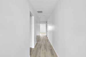 Hall featuring a textured ceiling and light wood finished floors