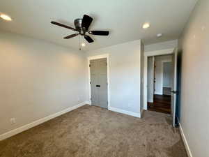 Unfurnished bedroom featuring carpet, recessed lighting, ceiling fan, and a closet