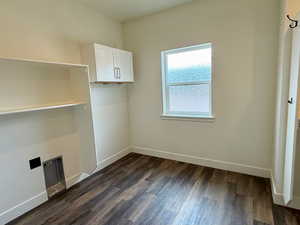 Laundry room with baseboards and dark wood finished floors