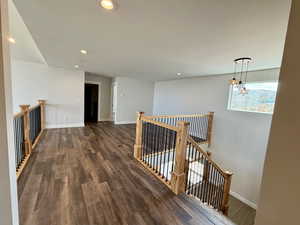 Hallway featuring an upstairs landing, recessed lighting, and dark wood finished floors