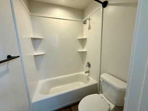 Bathroom with shower / bathtub combination and dark wood-type flooring