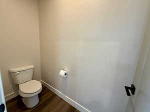 Bathroom with baseboards and dark wood-style flooring