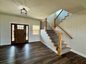 Foyer featuring dark wood-type flooring and stairway