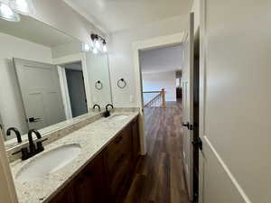 Bathroom with dark wood-type flooring and double vanity