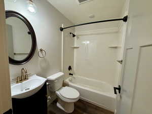 Full bath featuring vanity,  shower combination, and dark wood finished floors