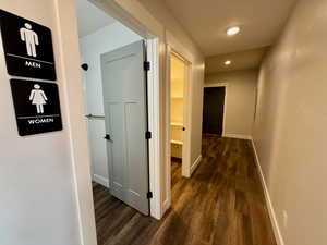 Hall with dark wood-type flooring and recessed lighting